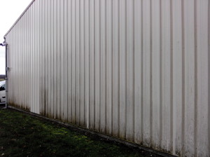 Côté du bâtiment attaqué de mainte fois, on remarque le bardage neuf suite aux cambriolages.